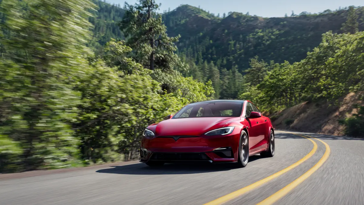 Tesla Model S piros színben menetközben.