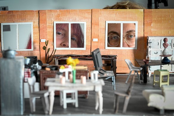 Isobel Knowles, left, and Van Sowerwine peer through the windows of one of their house models.