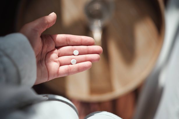 Morning after pill. Hand holding pills, close up cropped image. Emergency Contraception