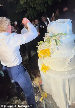 The guests also cheered on Jake in the background as pieces of the cake covered in a thick, white sugary frosting began to crumble to the ground