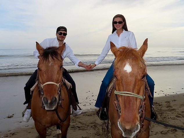 Brooklyn and Nicola holding hands while enjoying a horse ride on a beautiful beach
