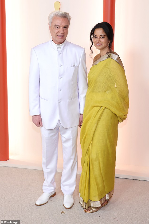 Talking Heads frontman David Byrne, 73, revealed he is engaged to his much younger girlfriend Mala Gaonkar, 55, after nearly a decade of dating; They are seen at the Oscars in 2023