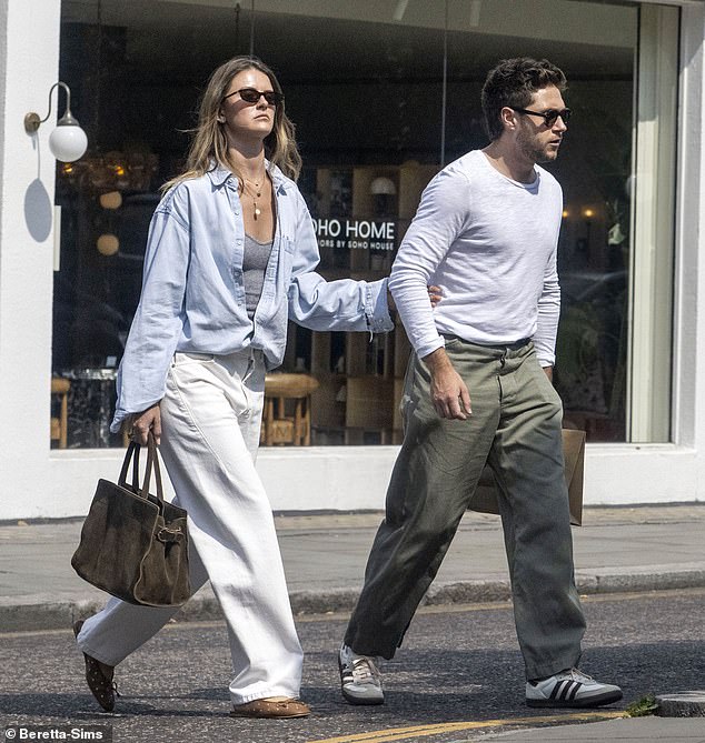 The couple looked in good spirits as Niall carried a shopping bag while holding hands with his glamorous girlfriend, 28