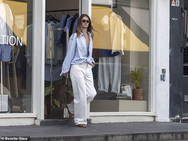 She toted her belongings in a stylish brown suede handbag and kept comfortable in a pair of flat coordinated sandals
