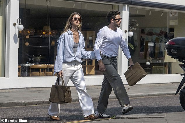 Leaving her long blonde tresses loose, Amelia accessorised by layering a number of gold necklaces and rocked a pair of sunglasses