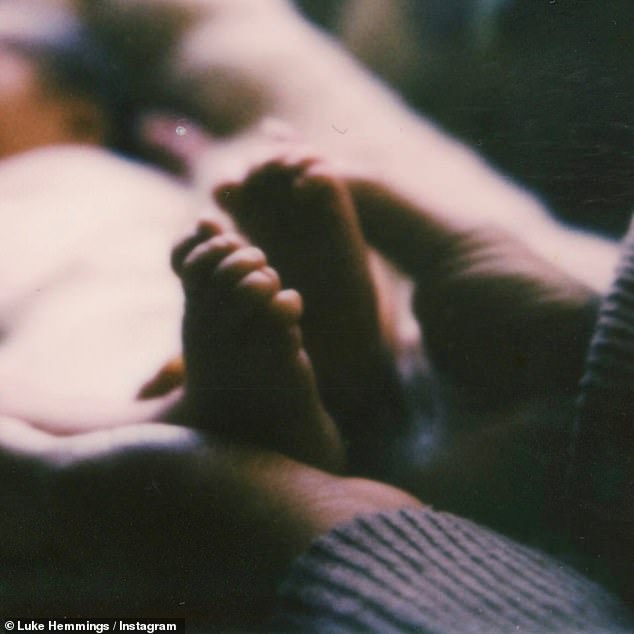 A snap showed the baby's feet, while another showed the baby holding a tiny bunch of flowers to their chest as the proud mum held their fingers