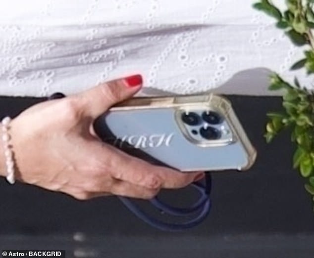 His female companion nailed summer chic in a white broderie anglaise dress paired with snakeskin print loafers, while toting a phone case emblazoned with the royal initials 'HRH'