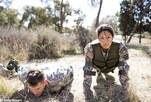 The new fitness trend inspired by military conditioning is a throwback to military rucking and athletic training. Pictured: A US Army man and woman wear weighted vests while doing pushups in a field