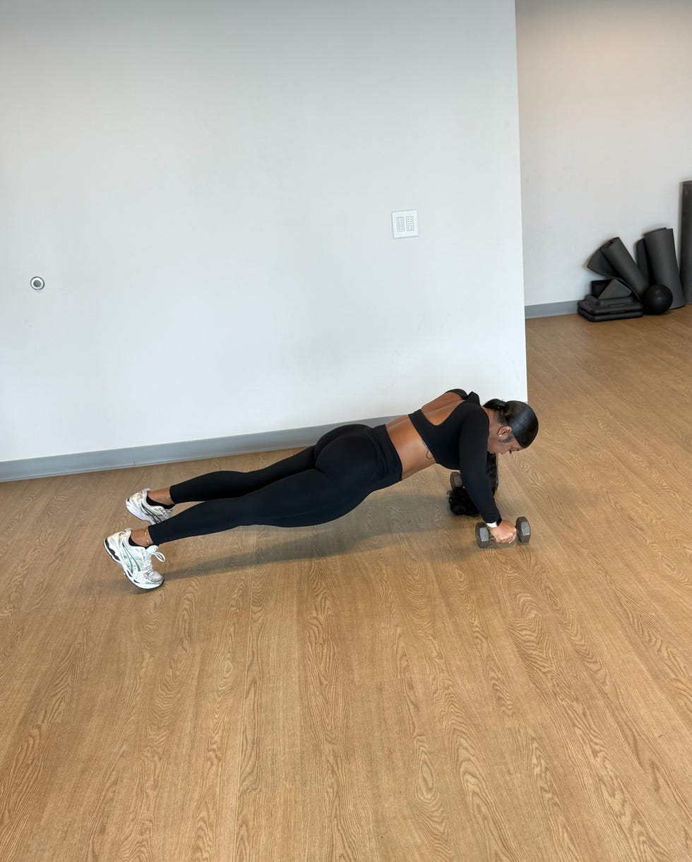 person performing a workout using a dumbbell in a fitness studio