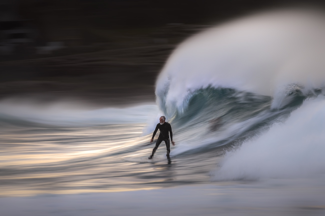 A older man surfer riding a wave on a winter morning at Bronte Beach in Australia