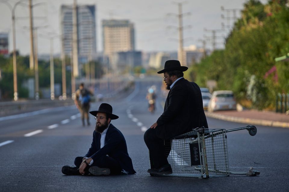 Ultra-Orthodox Jews block a highway during a protest against army recruitment, in Bnei Brak, Israel, Tuesday, Aug. 19, 2025. (AP Photo/Ohad Zwigenberg)