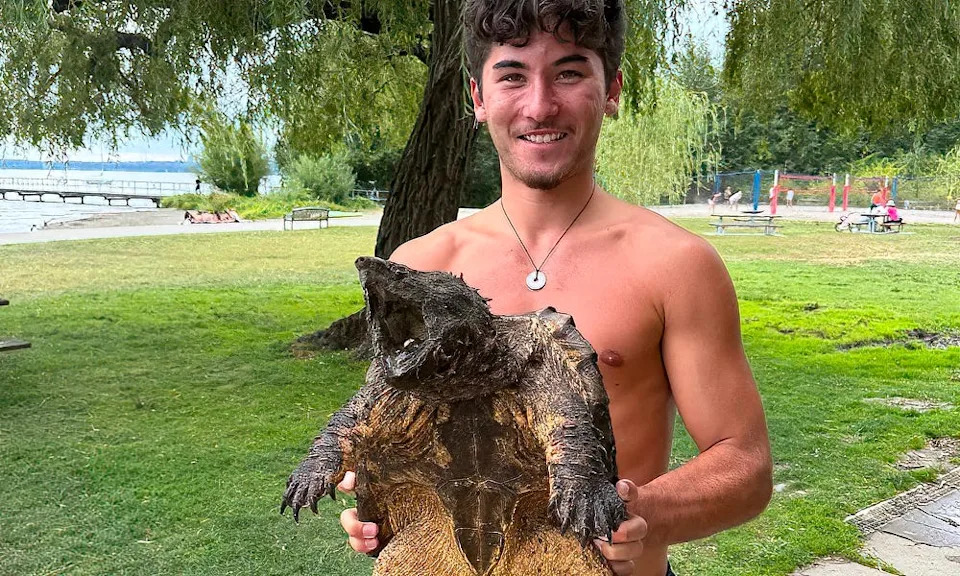Lifeguard supervisor Dani displays invasive reptile.
