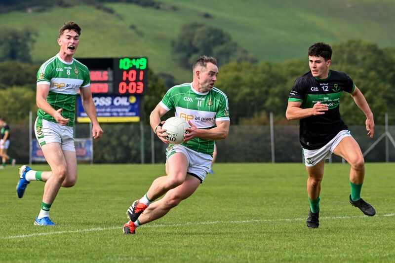 Aghabullogue captain John Corkery breaks forward from Nemo Rangers' Oisín White. Picture: Chani Anderson
