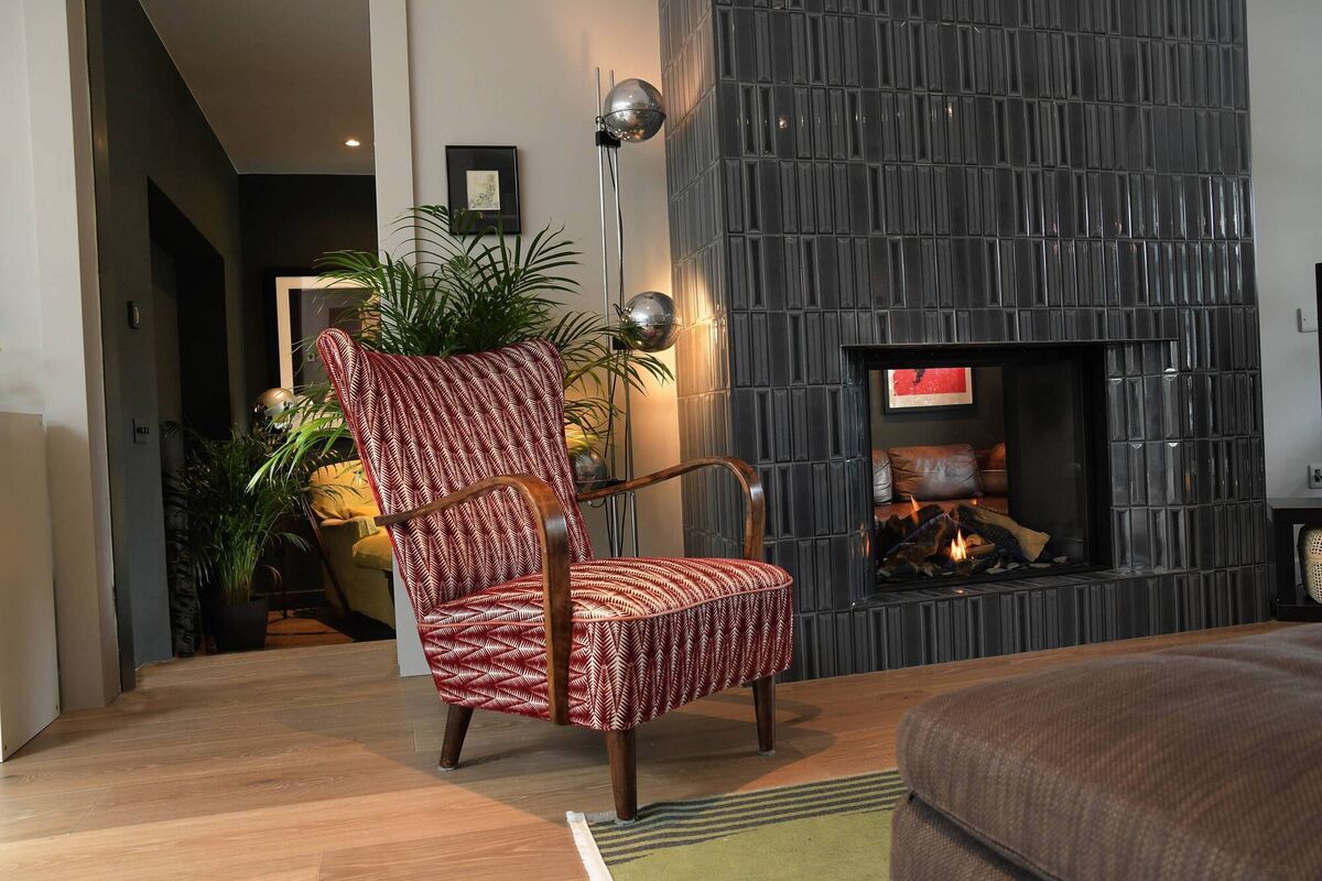 The sitting room where a double-sided stove offers a view to the kitchen/dining room. The sitting room where a double-sided stove offers a view to the kitchen/dining room.
