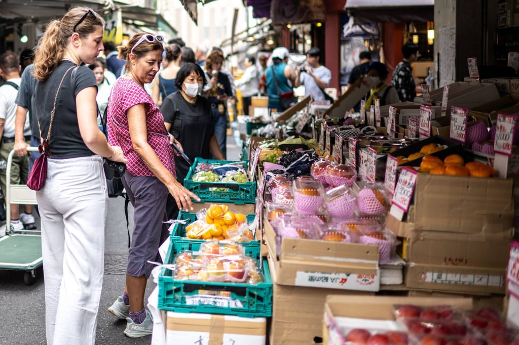 Tourists look at the fruit for sale at a market in Tokyo on Friday. Photo: AFP
