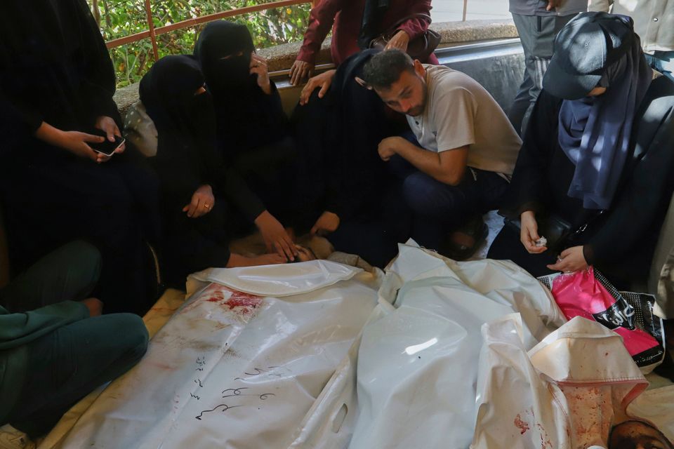 Palestinians mourn over the bodies of their relatives, who were killed in an Israeli airstrike, during their funeral at Nasser Hospital, in Khan Younis, in the southern Gaza Strip, Tuesday, Aug. 19, 2025. (AP Photo/Mariam Dagga)