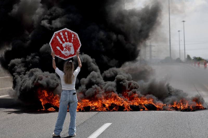 Protesters next to burning tires on the main road at Petah Tikva, Israel. Photograph: Atef Safadi/EPA

