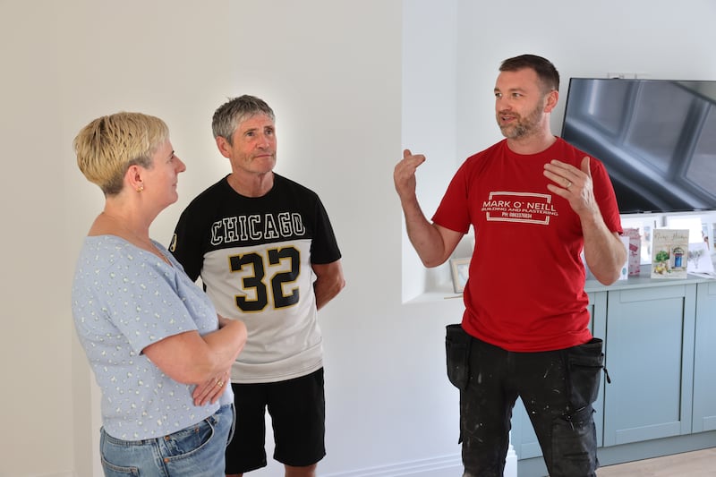 Pat Curran and his wife Breda in the newly rebuilt home with builder and plasterer Mark O’Neill. Photograph: Dara Mac Dónaill/The Irish Times