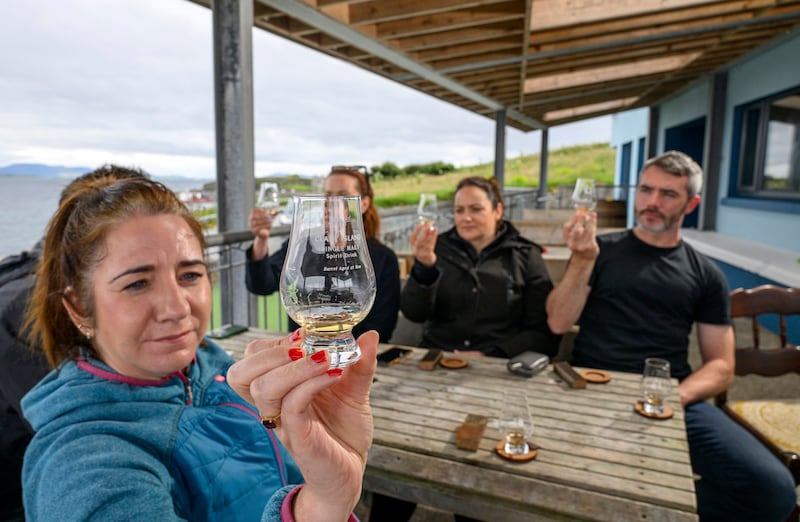 Guests at a tasting of Clare Island's sea-aged whiskey on the terrace, overlooking the Atlantic and Clew Bay.