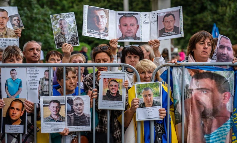 Ukrainians show portraits of their missing relatives to released Ukrainian prisoners of war following a prisoner-swap in Ukraine on Sunday. Photograph: EPA