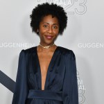 A Black woman in a blue dress on a red carpet.