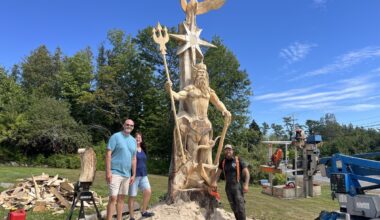 A chainsaw artist is carving Poseidon outside a Searsport motel