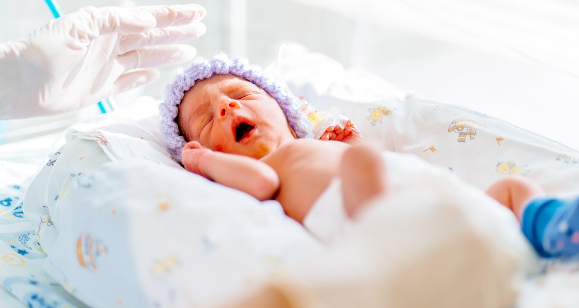 yawning premature born baby in intensive care unit
