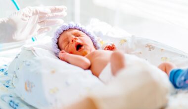 yawning premature born baby in intensive care unit