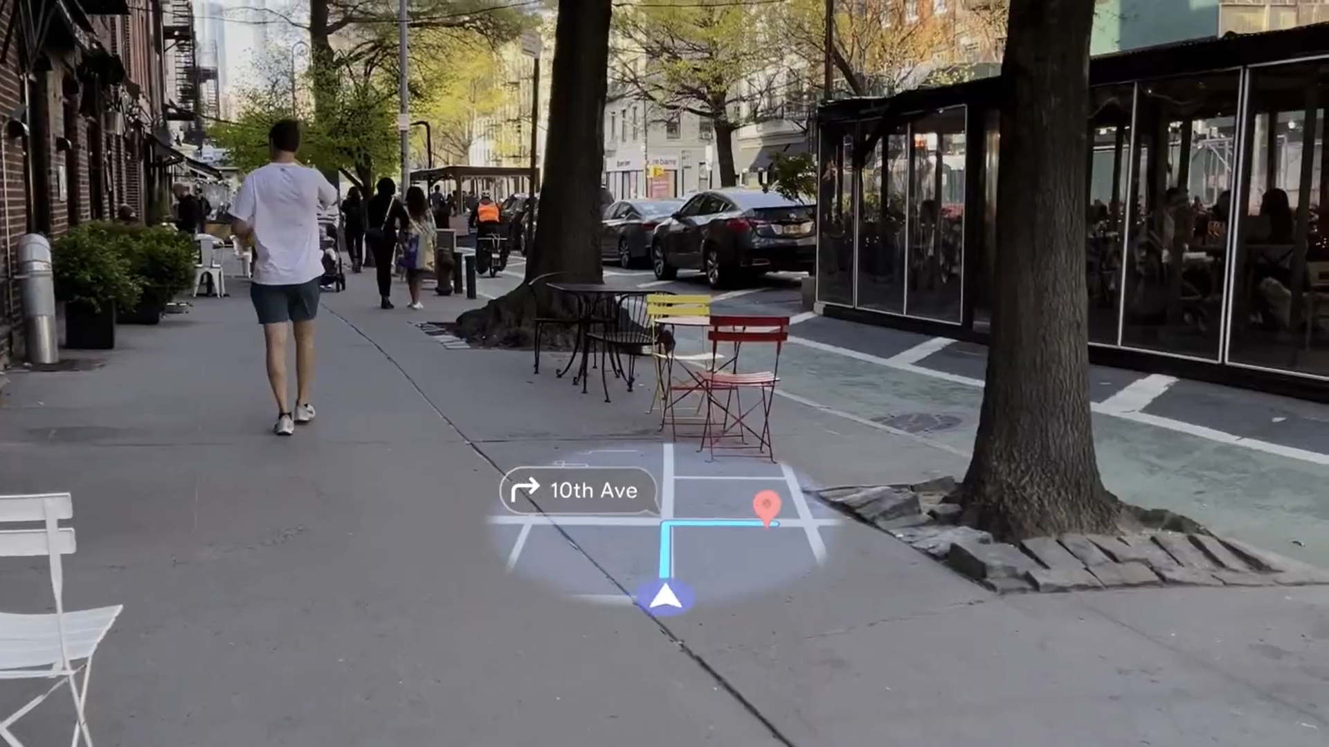 A still from an Android XR example video of how the software will work on smart glasses, showing someone navigating city streets with Google Maps, with a map view holograph showing when to turn.