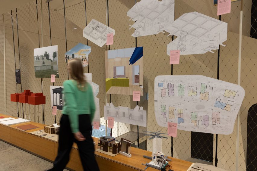 Student passing a wall of projects