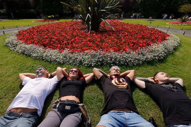 Maikel, Xary, Cateto and Jony from Spain listen to live lunchtime music from the bandstand in Dublin's St Stephens Green on Friday.  Photograph: Alan Betson