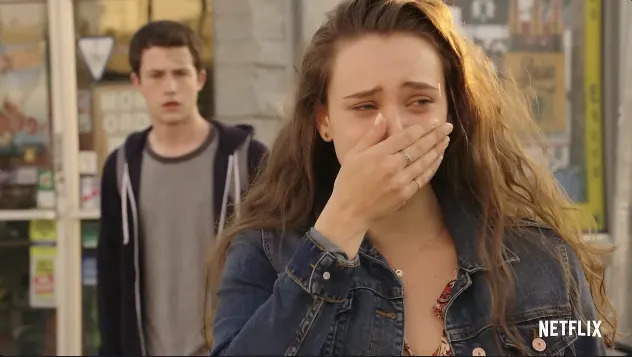 A distressed woman covers her mouth, with a concerned young man standing behind her