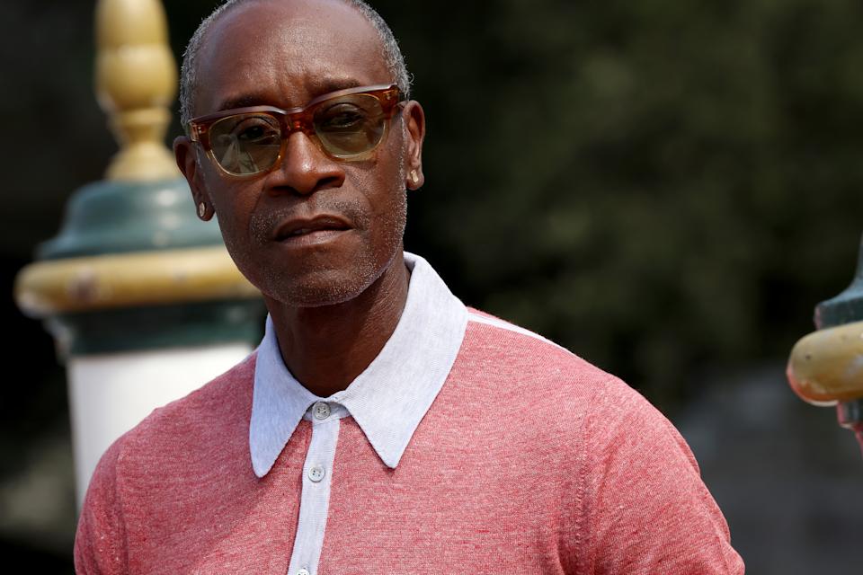 Don Cheadle wearing a collared sweater and glasses attends an outdoor event