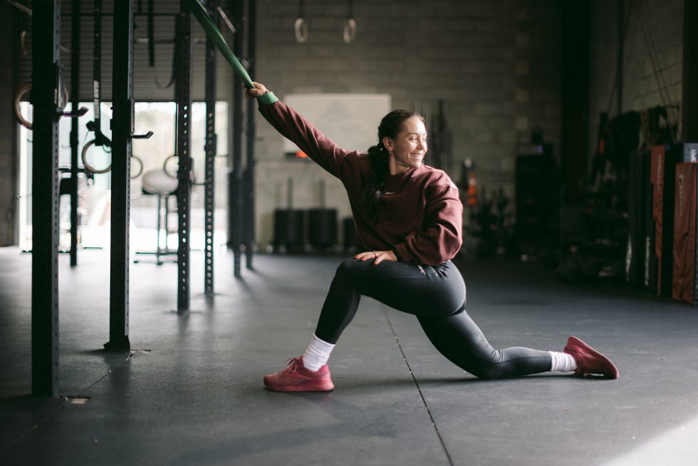 individual performing a stretching exercise in a gym individual performing a stretching exercise in a gym