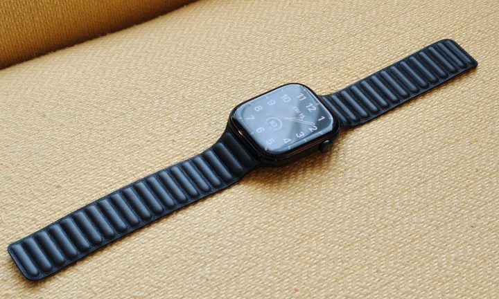 The Apple Watch Series 10, with a leather band, laying on a yellow chair.