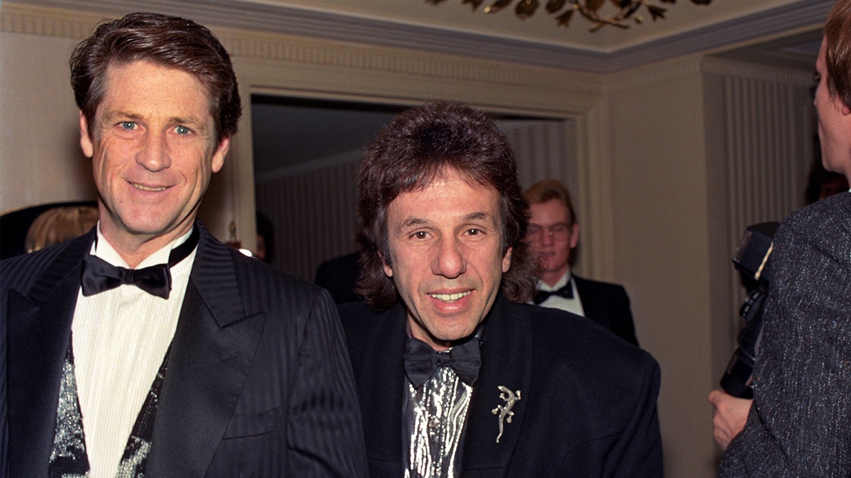 Brian Wilson in a tux smiling next to Dr. Landy also in a tux.