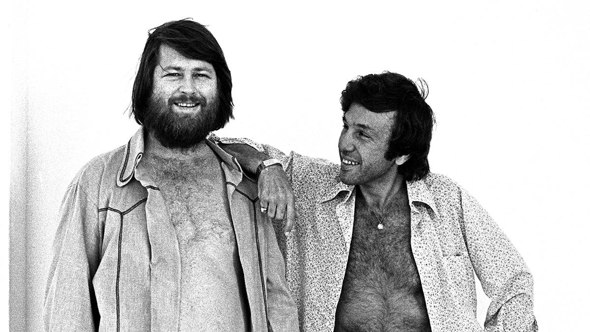 Brian Wilson smiling as Dr. Landy leans on him.