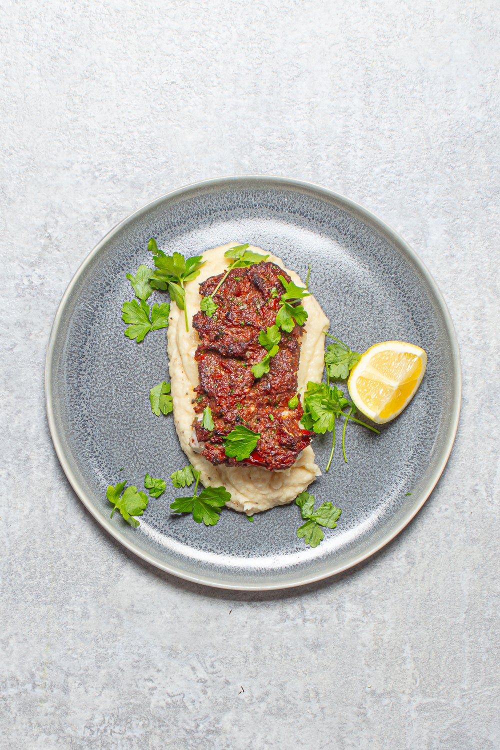 Herby baked cod with a zesty olive crust, proving creamy butter beans can outshine potatoes any day