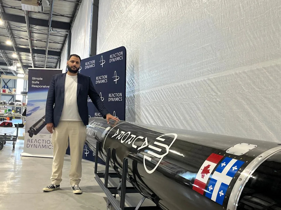 Bachar Elzein, founder and CEO of Reaction Dynamics, stands in front of a 1/3 mockup of the company's Aurora 8 rocket which the company plans to launch from Maritime Launch Service's site in Nova Scotia.