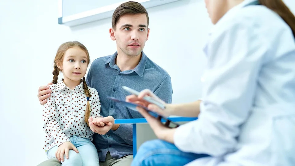 Girl with dad at doctor office