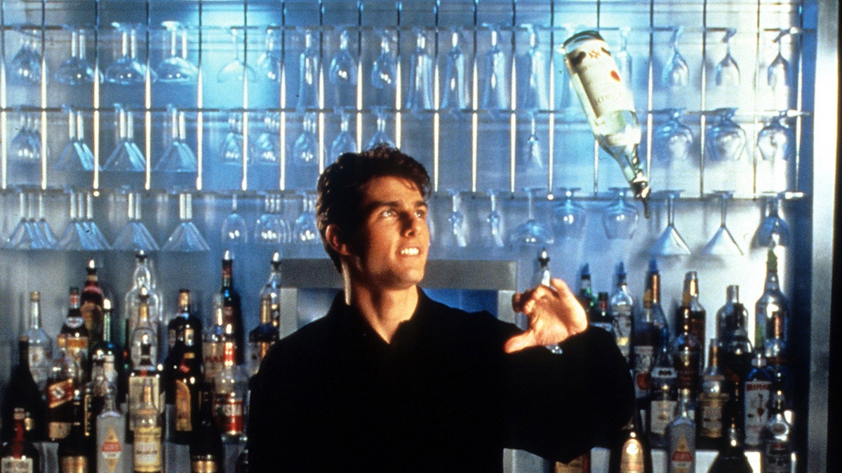 Tom Cruise at a bar about to catch a bottle mid-air.