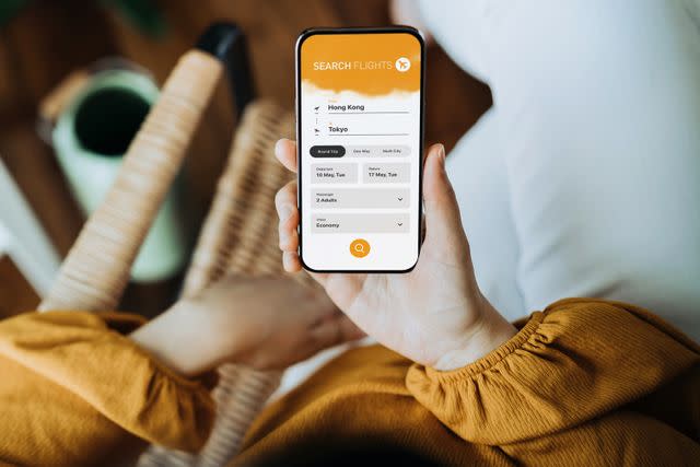 Getty Woman using a phone to book a flight (stock image).