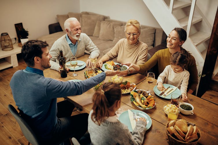 A happy extended family sitting around a table enjoying a meal