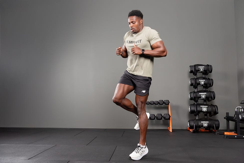 person performing a workout in a gym setting with weights in the background person performing a workout in a gym setting with weights in the background