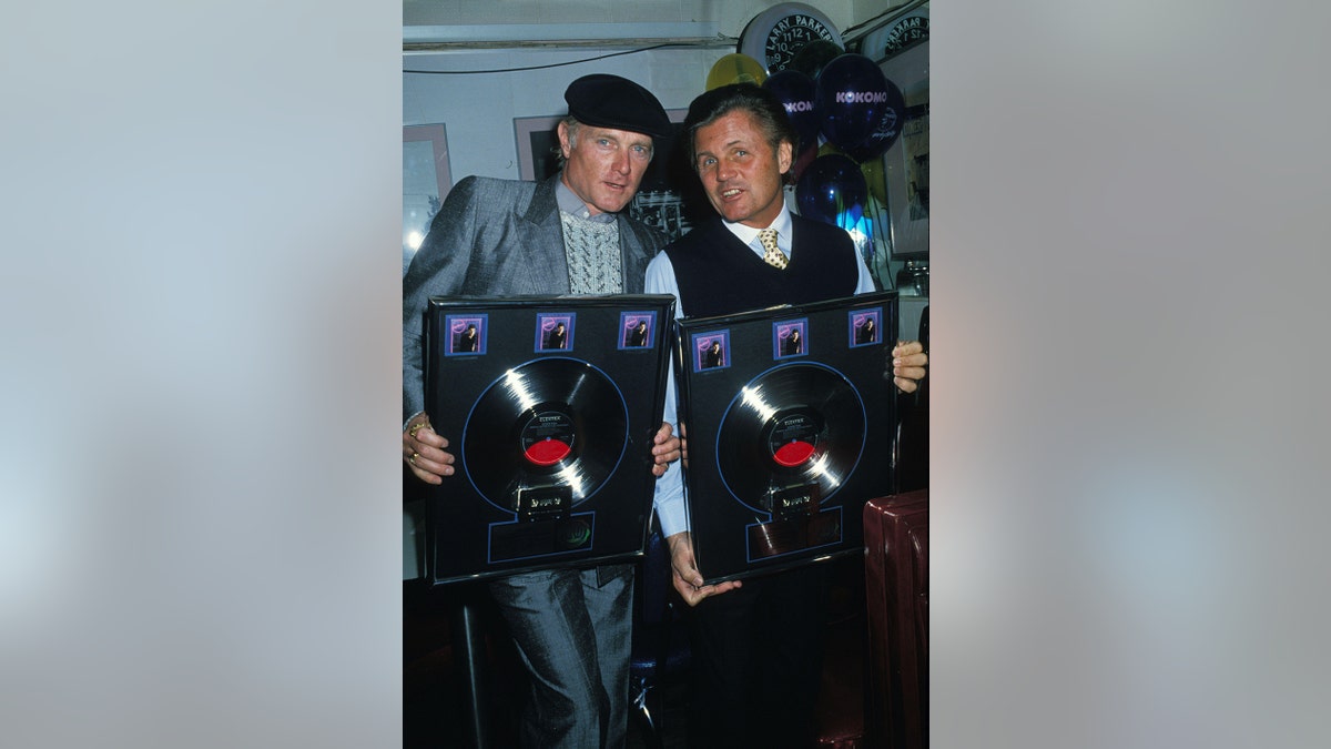 Mike Love and Bruce Johnson holding their records.