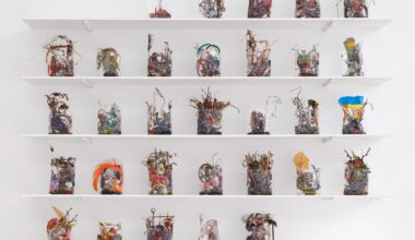 a collection of small ikebana-like sculptures in cellophane arranged like a month calendar on white shelves