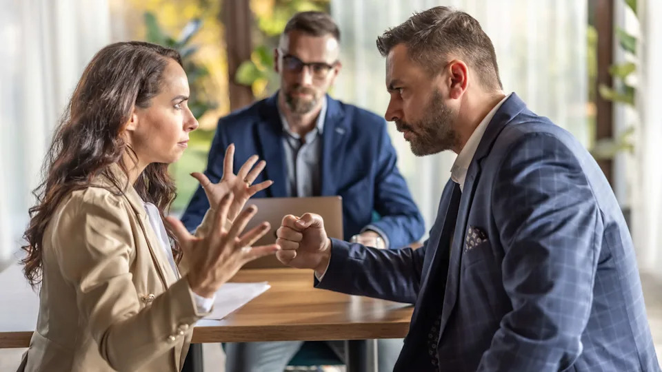 Annoyed unhappy married couple arguing in lawyers office. (Getty Images)