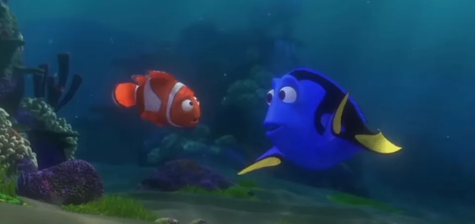 A clownfish and a blue tang fish converse underwater in an animated movie scene
