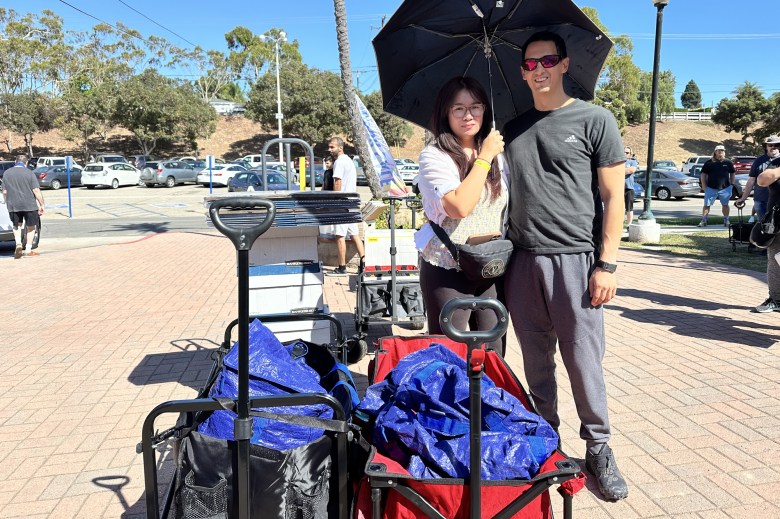 Bookseller duo Alyssa and Michael Lopez of Sacramento arrive to the book sale prepared with two wagons and moving bags.