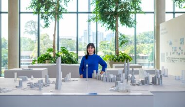 Sarah Merican, Partner at GDP Architects, stands beside a detailed architectural model of Kuala Lumpur’s skyline at the “group, design, partnership” exhibition, showcasing the firm’s contribution to Malaysian architecture over 35 years of practice at GDP Campus